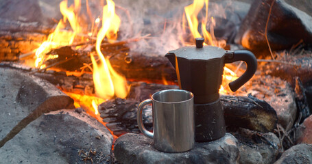 Coffee is prepared in a geyser coffee maker on a campfire