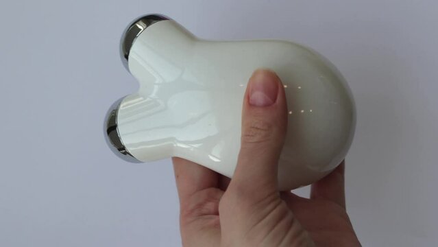 Microcurrent Facial Massager in woman's hands. Microcurrents to relax facial muscles from wrinkles