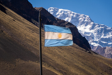 Argentine flag fluttering in the wind, behind the Aconcagua hill in Mendoza Argentina
