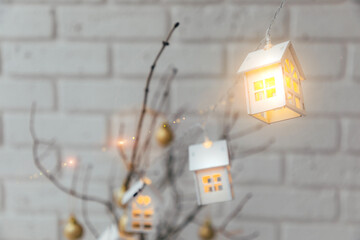 Garland in the form of wooden houses with yellow bulbs close-up. Christmas background