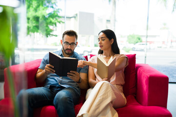 Attractive young couple reading a book on the sofa