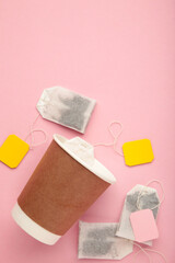 Disposable takeaway cups with tea bag on pink background, including clipping path. Space for text