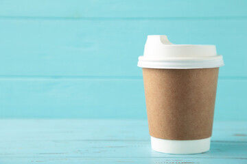 Craft paper cup with space for text on blue background.