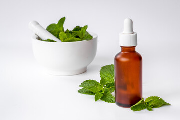 Peppermint essential oil - source of menthol. Mint leaves with bottle of oil