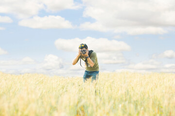 Man taking a photo in the meadow rice field with blue sky background