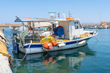 Fototapeta na wymiar A few traditional fishing boats moored in the old harbor of Chania, Crete, Greece