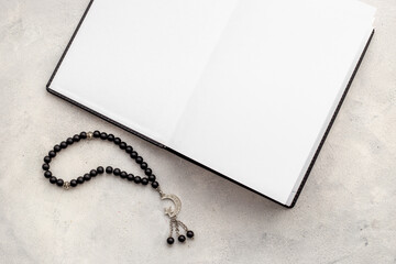Black Islamic rosary with silver muslim crescent moon on Koran book