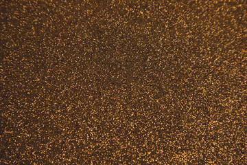 Shiny golden blurred background for holiday design. Christmas abstract sparkles, selective focus