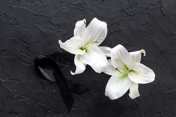 Two white liles flowers with black ribbon. Mourning or funeral background