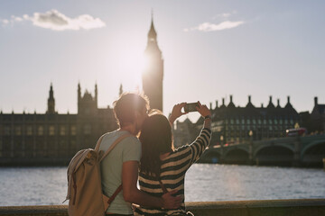 Phone, selfie and couple by the big ben in London on vacation, adventure or holiday together....