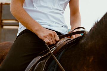 The boy is holding the horse's reins. Prepared for horse riding on Supertubos beach in Peniche in...