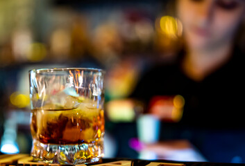 Bartender hand pouring whiskey on glass in bar
