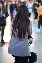 Fototapeta premium A young woman with long brown hair is waiting for her train in Valencia-Spain.