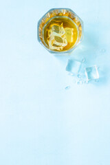 Obraz na płótnie Canvas Glass of whiskey or brandy with ice. Strong alcohol background