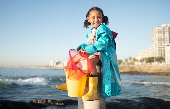 Ocean, Fishing And Portrait Of Girl With Smile Sitting On Dock, Fun And Happy Day At Beach Holiday On The Weekend. Nature, Blue Sky And Waves, Child At The Sea With Net Ready To Catch Fish In Water