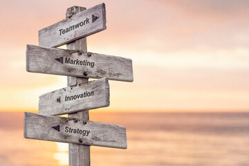 teamwork marketing innovation strategy text written on wooden signpost outdoors at the beach during sunset