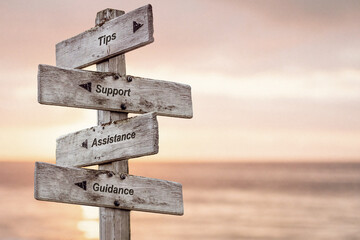 tips support assistance guidance text written on wooden signpost outdoors at the beach during sunset