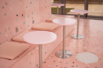 Empty pink bar tables in an ice cream parlour.