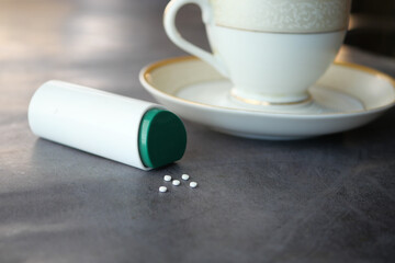artificial sweetener and tea cup container on table 