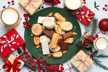 Top view of Nougat christmas sweet,mantecados and polvorones with christmas ornaments on a plate. Assortment of christmas sweets typical in Spain