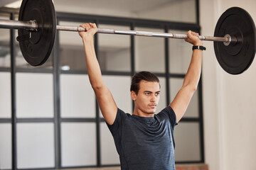 Strong man, overhead barbell and gym exercise, workout and fitness training in sports club. Young...
