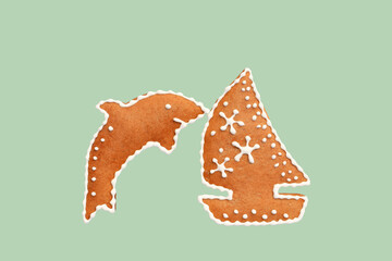 Gingerbread dolphin and sailing boat isolated on green background. Romantic summer concept