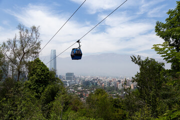 Cable car cabin moving along the Metropolitan Park of San Cristobal Hill, with panoramic view of...
