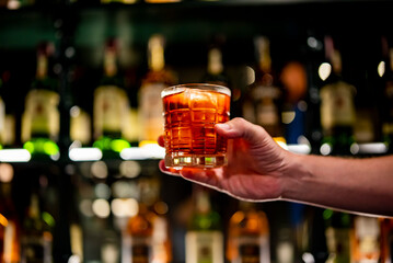 male hand holding a glass of coktail in a bar