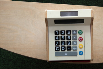 calcolatrice giocattolo vista dall'alto su legno chiaro 