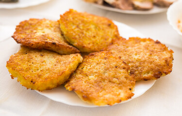 Potato pancakes with sour cream on white plate