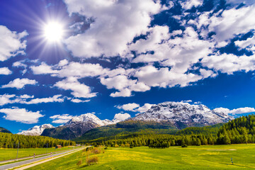 Green fields and Alps mountains coevered with forest, Samedan, M