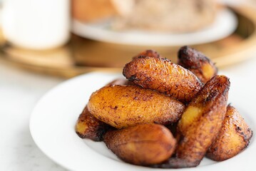 Closeup of fried sweet plantains on a plate. - obrazy, fototapety, plakaty