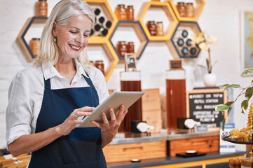Happy small business owner, tablet or senior woman in honey retail store for research,...