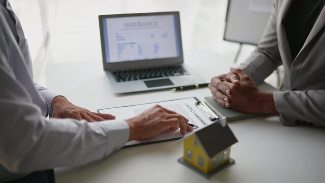 Close up of business's hands selling and signing agreement paperwork for loan financial to buying the house properties.