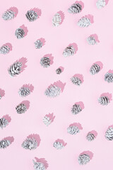 Snowy winter pine cones on a pink background. Aesthetic Christmas background.