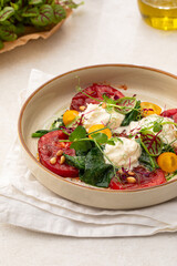 Portion of grilled tomatoes and stracciatella cheese