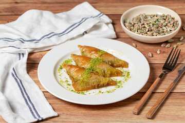 Sobiyet baklava with pistachio on wooden background. Turkish cuisine delicacies. Turkish baklava. close up
