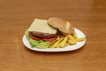 Classic and humble beef burger with slice of cheese and tomato slices with village bread