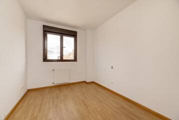 Empty living room with oak-look laminate flooring with bare white walls and aluminum window with a view