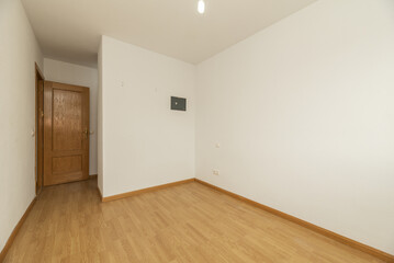Empty living room with French oak parquet flooring with bare white walls and pinewood doors and a small built-in wall safe