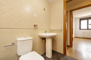 Small cloakroom with pedestal porcelain sink and square tiled walls and oak woodwork