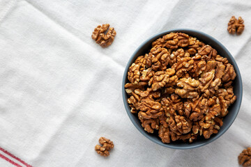 Raw Organic Walnuts in a Bowl, top view. Flat lay, overhead, from above.