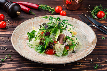 Fresh green salad with beef tongue, cheese, olives, cucumbers, lettuce, cherry tomatoes, arugula...