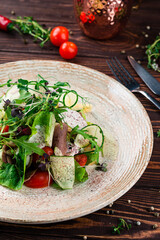 Fresh creen salad with beef tongue, cheese, olives, cucumbers, lettuce, cherry tomatoes, arugula, spices and microgreens.