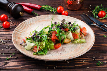 Salad with salmon, fried potatoes, poached egg, cherry tomatoes, lettuce, microgreens, arugula and dressing.