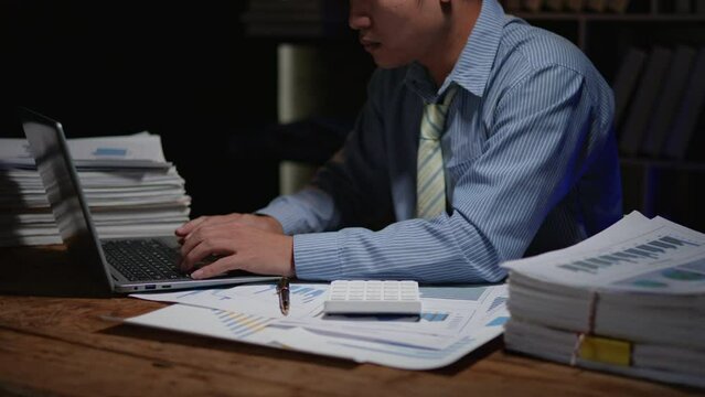 Close up of business hands working overtime night shift and calculating on financial and accounting graft and chart in office space
