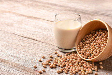Glass of soy milk isolated on wooden table background.