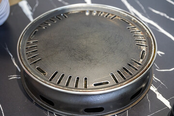 Close-up of a stainless steel grill pan used in a rotisserie