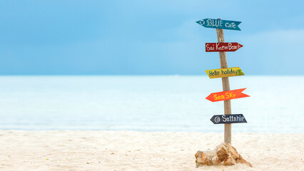 Wooden signboard from arrows on the beach.  Beautiful nature see background.  Summer Concept, copy space for banner