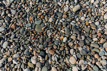 Small round stones background. Stone texture. Rough surface of small pebble stone.